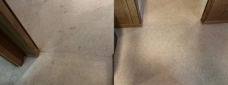 Carpet at the base of a wooden dresser, greyed with traffic soil, then clean