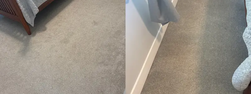 Light grey carpet beside a wooden bed frame, and carpet along a white door and baseboard