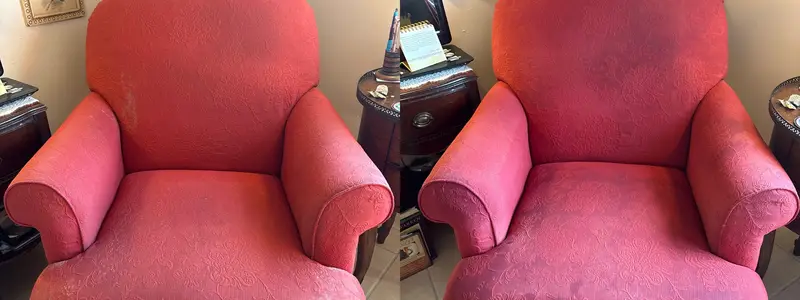 Red upholstered armchair with pale worn patches on the arms, color even after cleaning